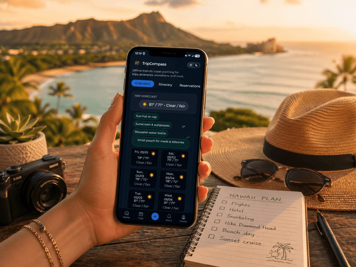 Hand holding a smartphone with a travel app against a scenic tropical beach sunset background.